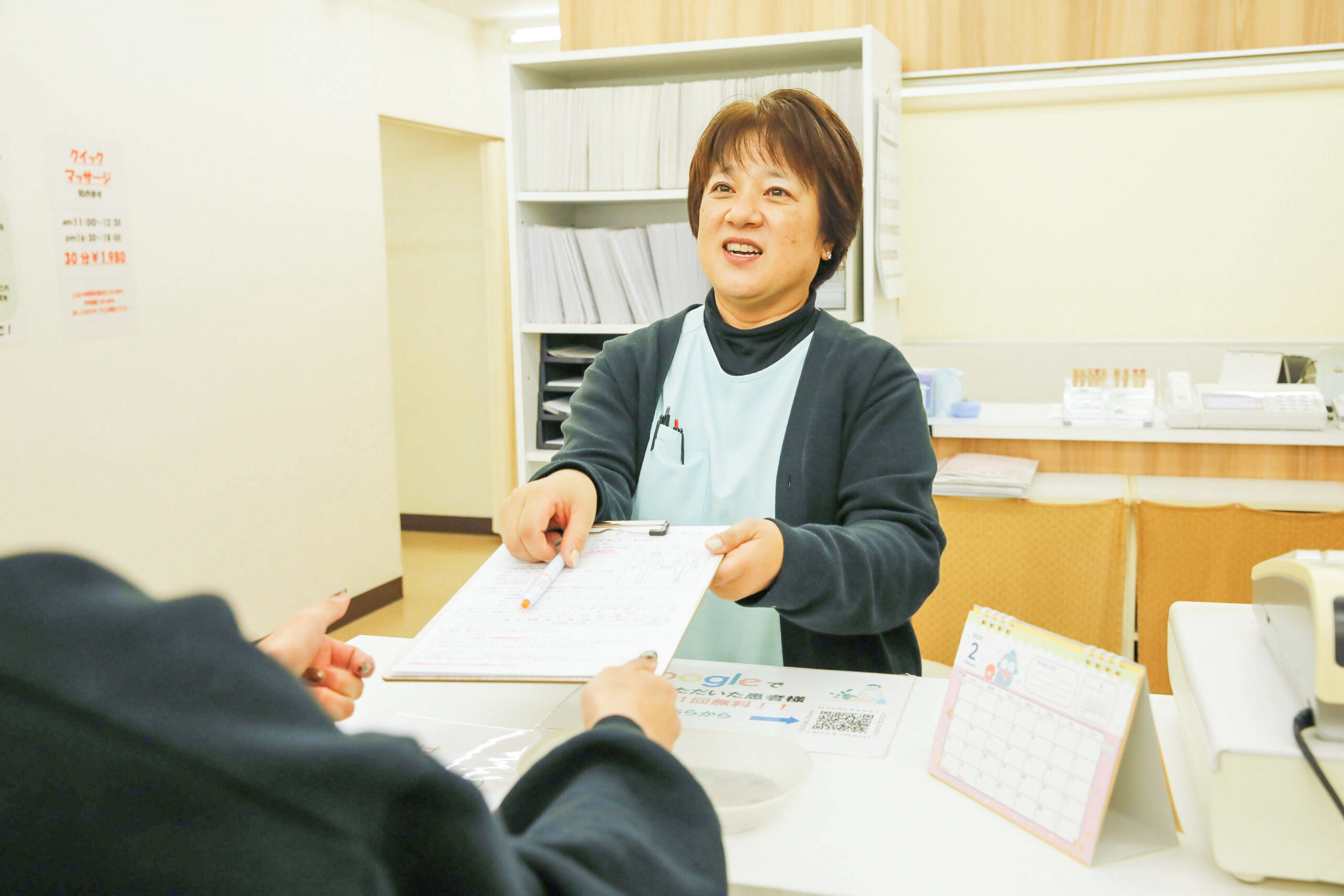 問診票を手渡す山田さん